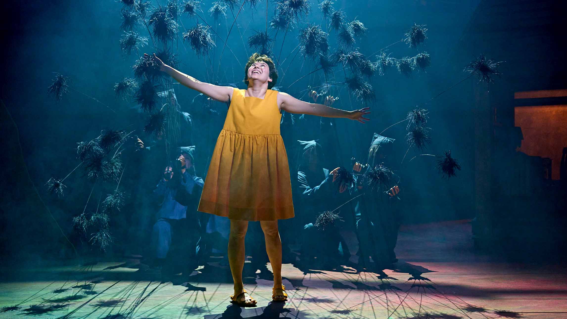 An actor with arms outstretched in My Neighbour Totoro theatre production at the Gillian Lynne Theatre, London