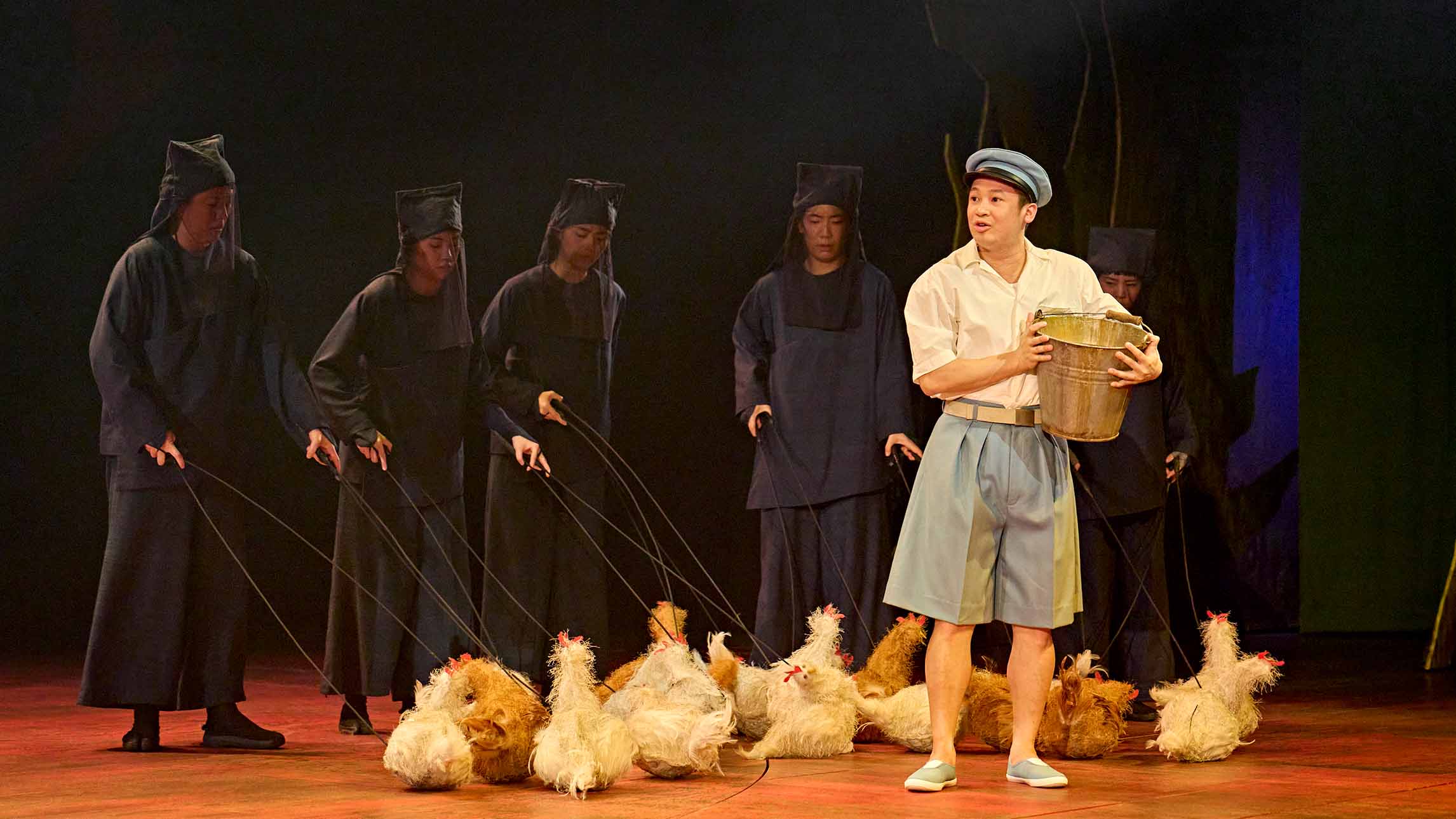 An actor with puppet chickens from My Neighbour Totoro theatre production at the Gillian Lynne Theatre, London