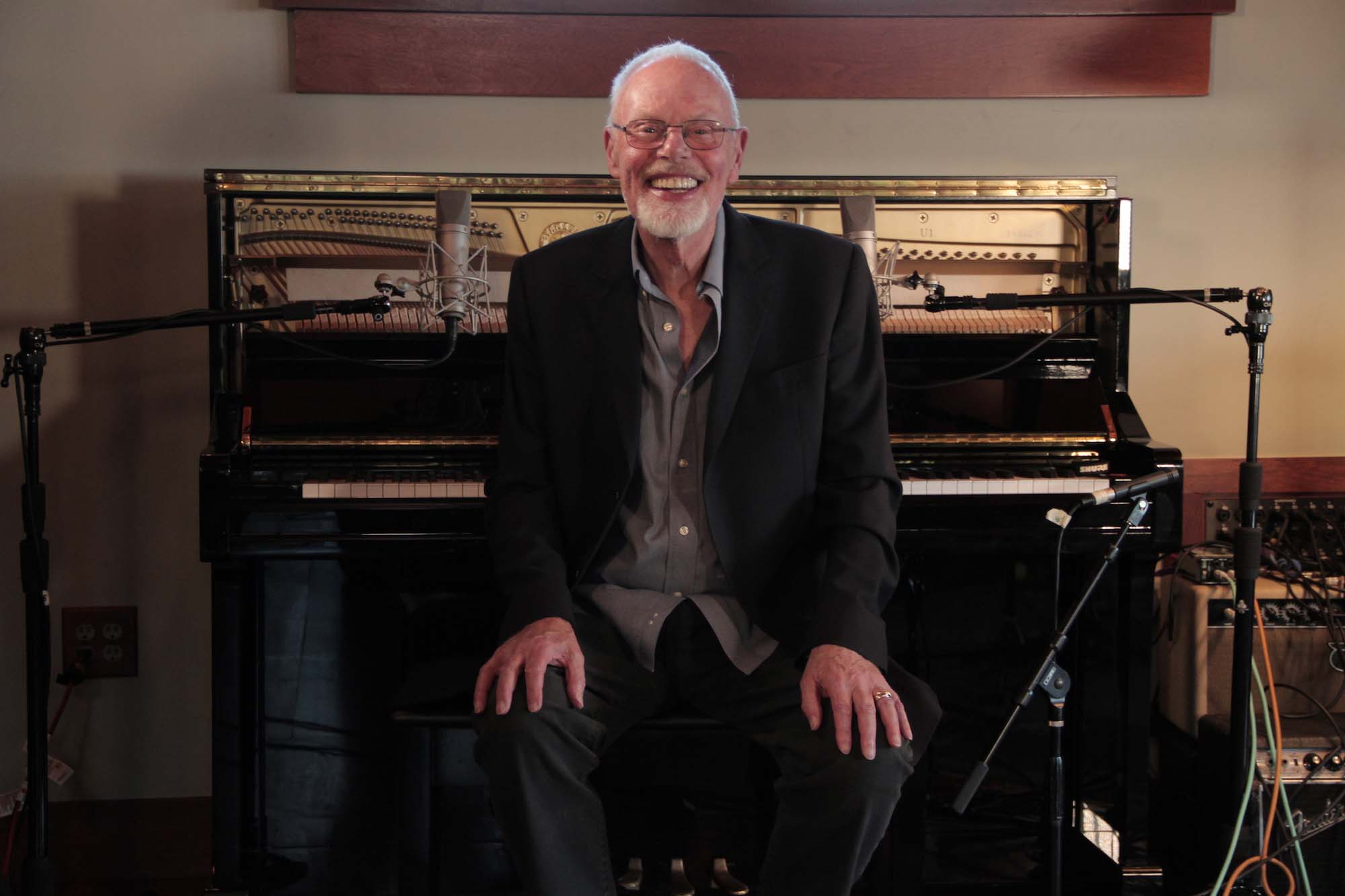 Bob Harris OBE sitting at a piano