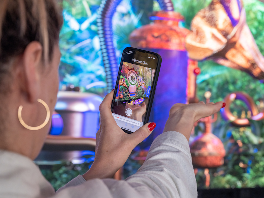 Woman capturing the Butterfly Trail experience on a mobile phone