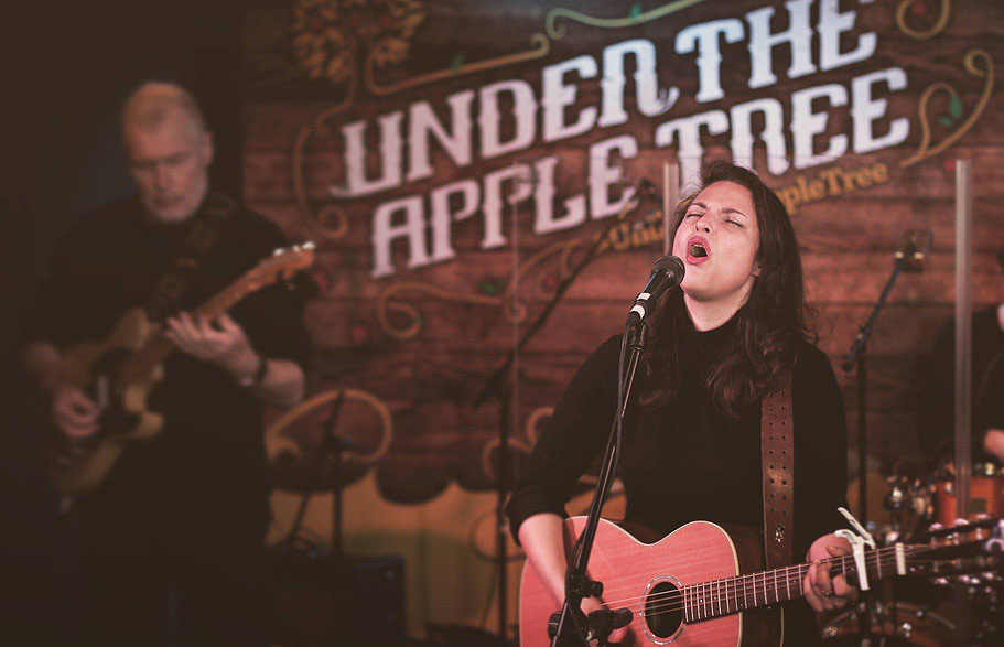 Danni Nicholls singing and playing guitar