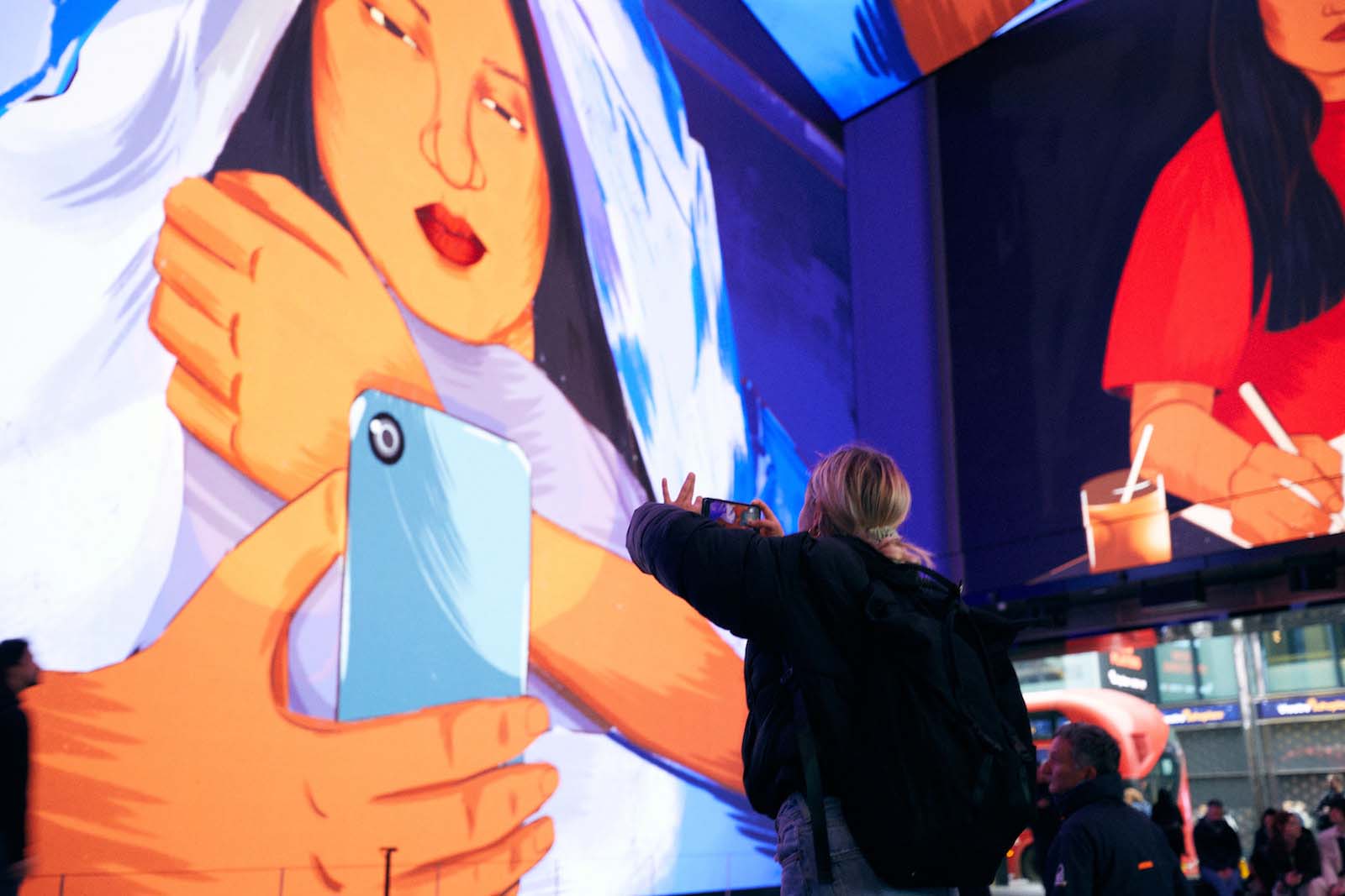 Woman taking a photo of Women In Art display