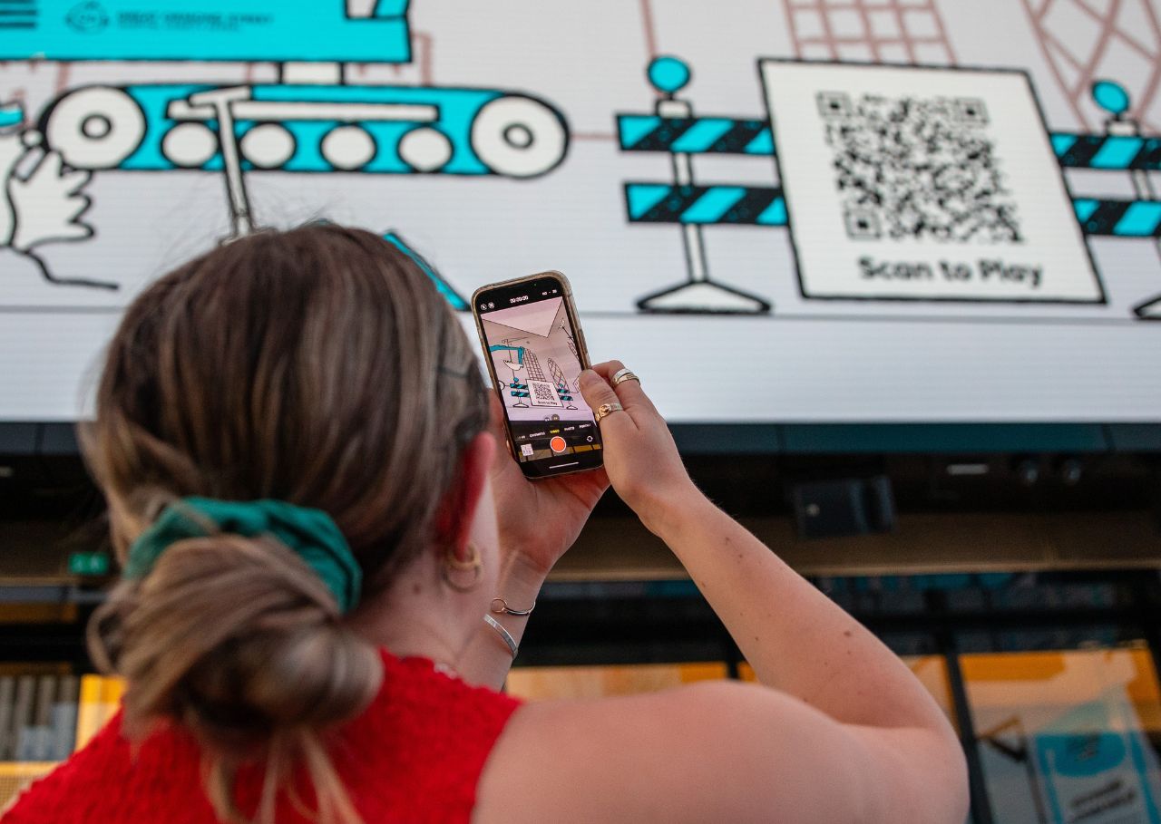 Woman scans to play GOSH Big Build Adventure